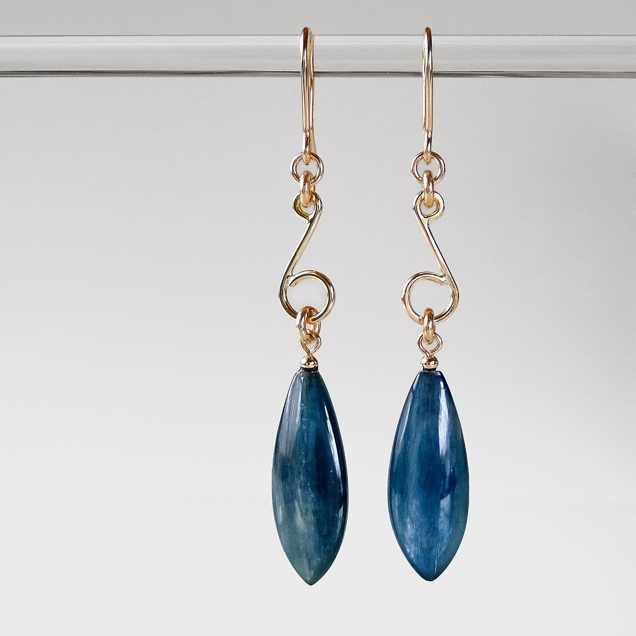 Gold drop earrings set with marquise-cut deep blue stones