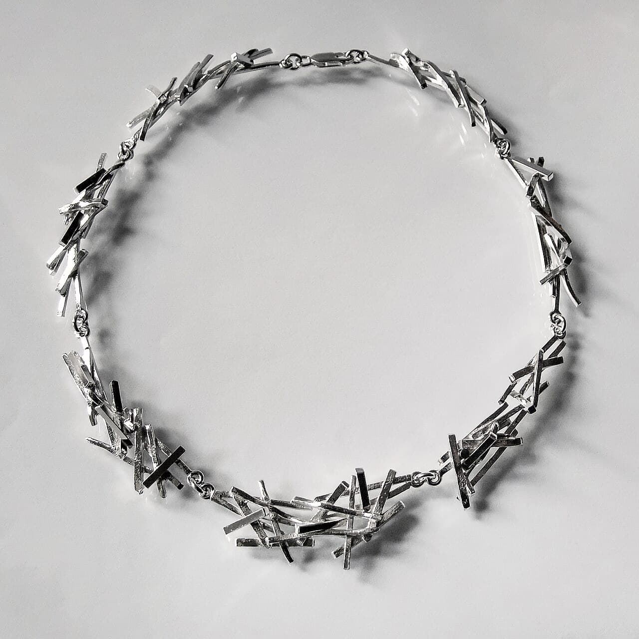 Sterling silver necklace of hand-shaped open links, laid flat